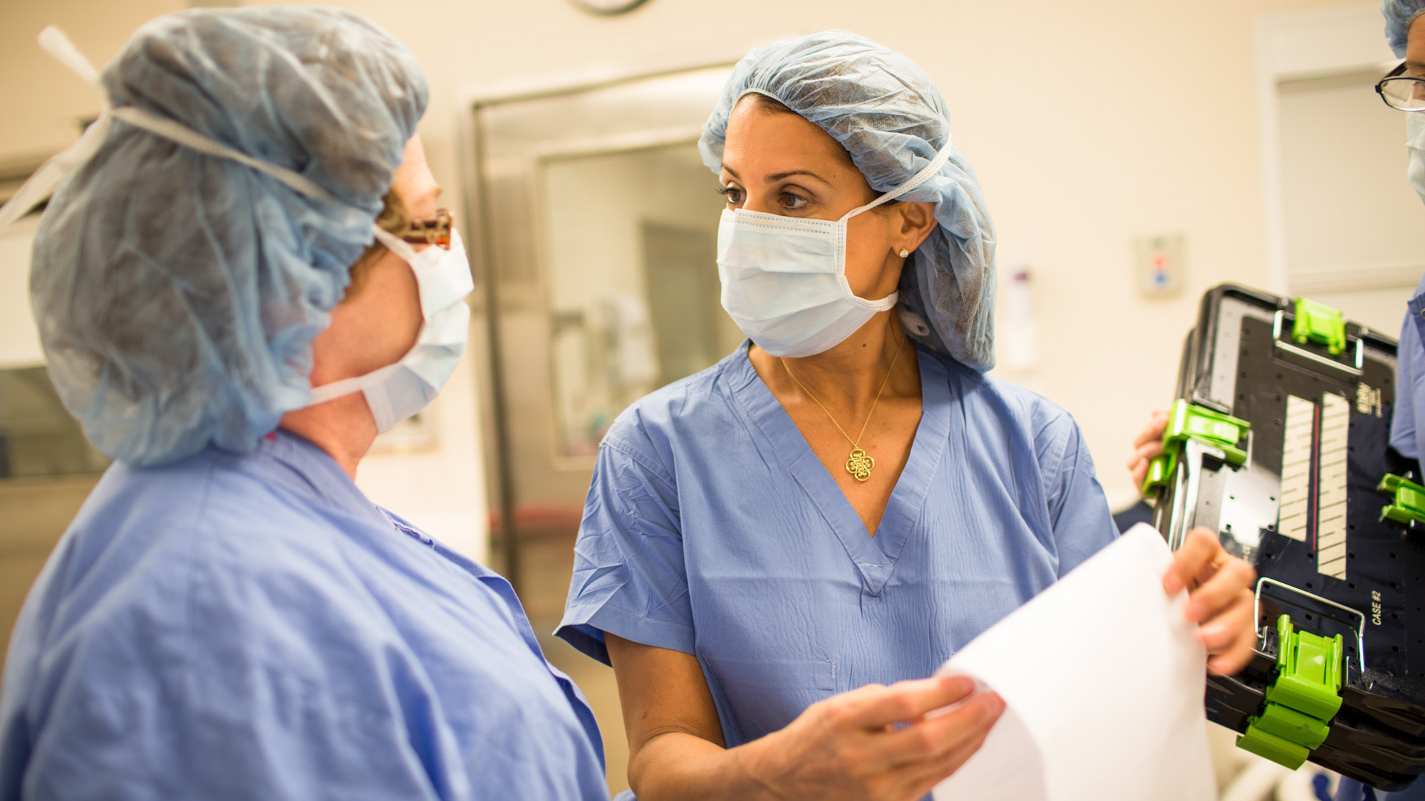 female surgeons confer over readout