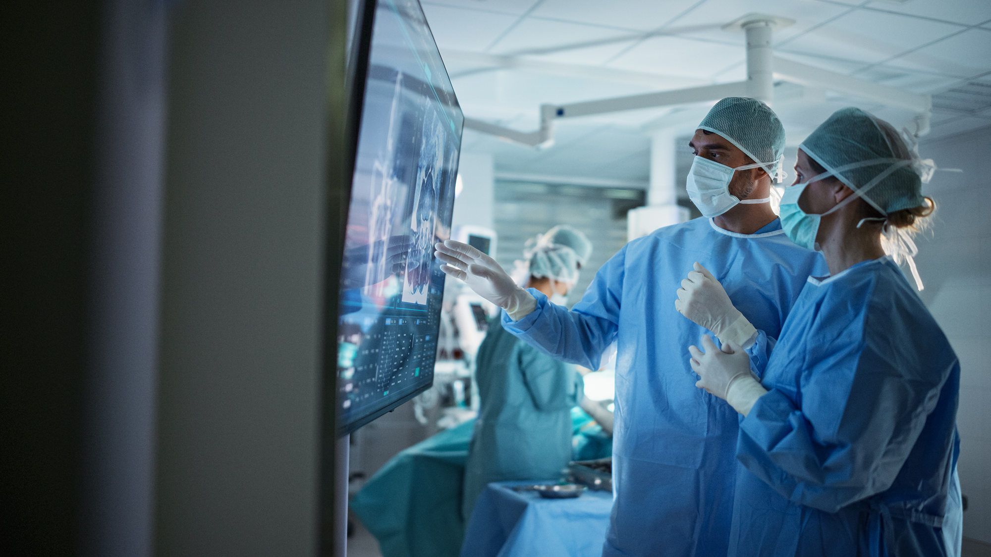 two clinicians discussing a chart on a screen
